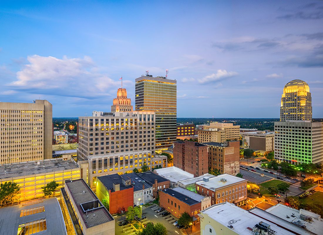 Winston-Salem, NC - View of Commercial Buildings in Downtown Winston-Salem North Carolina in the Evening with a Cloudy Sky